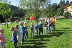 Kinder stehen in einer Reihe auf einer Wiese