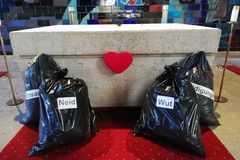 Schwarze Müllsäcke mit der Aufschrift Neid, Beleidigungen, Einsamkeit und Wut stehen vor dem Altar in der Friedenskirche