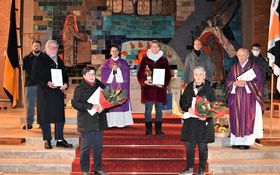 4 Kolpingmitglieder, Kolpingvorstand Andrea Greiner, zwei Priester und zwei Fahnenabordnungen stehen im Altarraum der Friedenskirche Grafenwöhr
