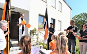 Pfarrer Fenk mit Stola und zwei Luftballons in den Händen umringt von der Kolpingsfamilie Grafenwöhr