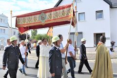 Priester mit Monstranz unter einem Himmel