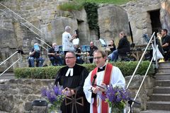 Katholischer und evangelischer Pfarrer hinter einem Altar auf dem Schönberg, im Hintergrund der Posaunenchor Neustadt am Kulm