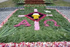 Blumenteppich mit Kelch und Alpha und Omega Symbol
