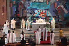 Pfarrer Daniel Fenk hinterm Altar der Friedenskirche umgeben von weiteren Priestern und Ministranten