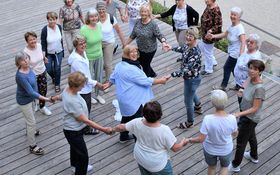 Frauen Hand in Hand im Kreis beim Tanzen