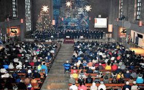 vollbesetzte weihnachtlich geschmückte Friedenskirche, in der im Altarraum ein großer Chor mit 85 Teilnehmer*innen steht.