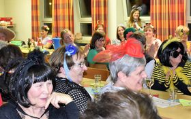 verkleidete Frauen beim Fasching sitzend an den Tischen