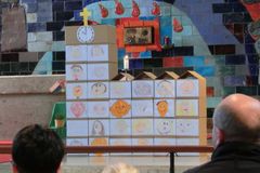 eine Kirche aus Kartons gestapelt, auf den Kartons sind selbst gemalte Kinderportraits