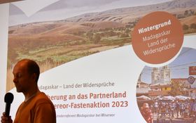 Christian Baumann stellt vor einer Leinwand das Land Madagaskar vor