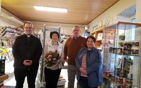 Doris Bernhardt mit Blumenstrauß eingerahmt von den beiden Pfarrern der Gemeinde Grafenwöhr und einem Mitglied des AK Ökumene