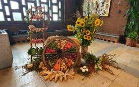 großes Wagenrad dekoriert mit Früchten und Gemüse zum Erntedank