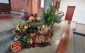 Erntedankaltar neben Ambo mit Blumen, Gemüse und Obst