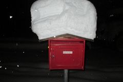 roter Briefkasten mit dicker Schneehaube