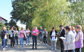 Frauen stehen im Freien auf einer Flur und beten