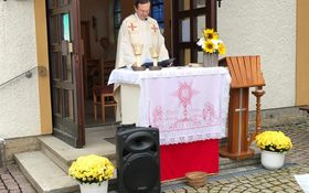 Priester hinter einem Altar im Freien vor der St. Michaelskapelle in Gößenreuth