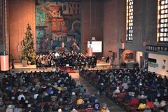 mit Menschen voll besetzte Kirche, im Altarraum ein großer Chor