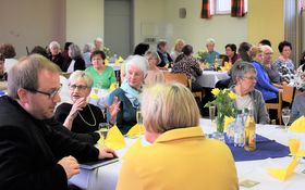 Menschen sitzen um gedeckte Tische